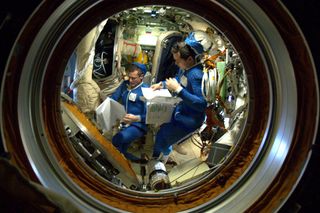 Russian cosmonauts Dmitry Kondratyev and Oleg Skripochka preparing for their spacewalk. This image was taken on Jan. 18, 2011 by astronaut Paolo Nespoli on the International Space Station.
