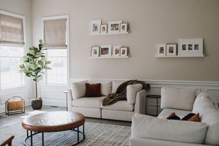 Living room with pale plaster walls white sofas and round coffee table