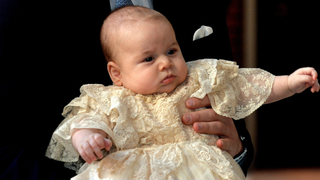 Britain's Prince William, Duke of Cambridge holds his son, Prince George of Cambridge, as he arrives at Chapel Royal in St James's Palace in central London for the christening of the three month-old baby on October 23, 2013