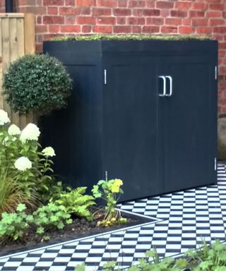black bespoke bin storage alongside a Victorian-style garden path in a front garden