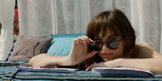 Fifty Shades Freed Dakota Johnson Anastasia peering out from behind her sunglasses