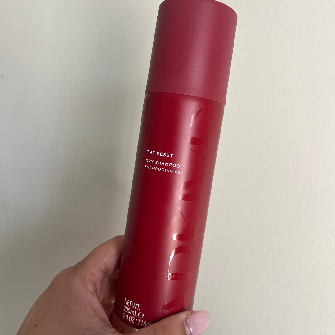Hand holding an empty red can of Arkive The Reset Dry Shampoo