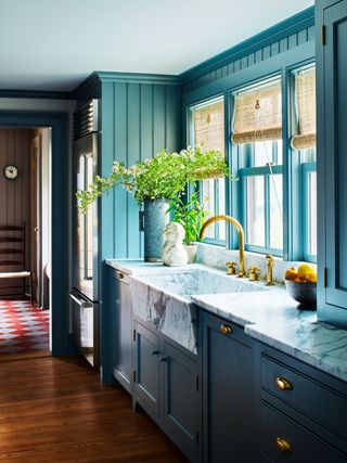 Blue kitchen with bamboo blinds over sink