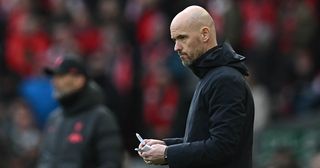 Manchester United manager Erik ten Hag makes notes during the English Premier League football match between Liverpool and Manchester United at Anfield in Liverpool, north west England on March 5, 2023.