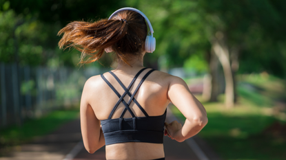 Woman running with headphones on outside