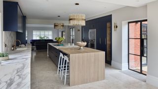 large kitchen with island, navy units, wood and marble large kitchen island