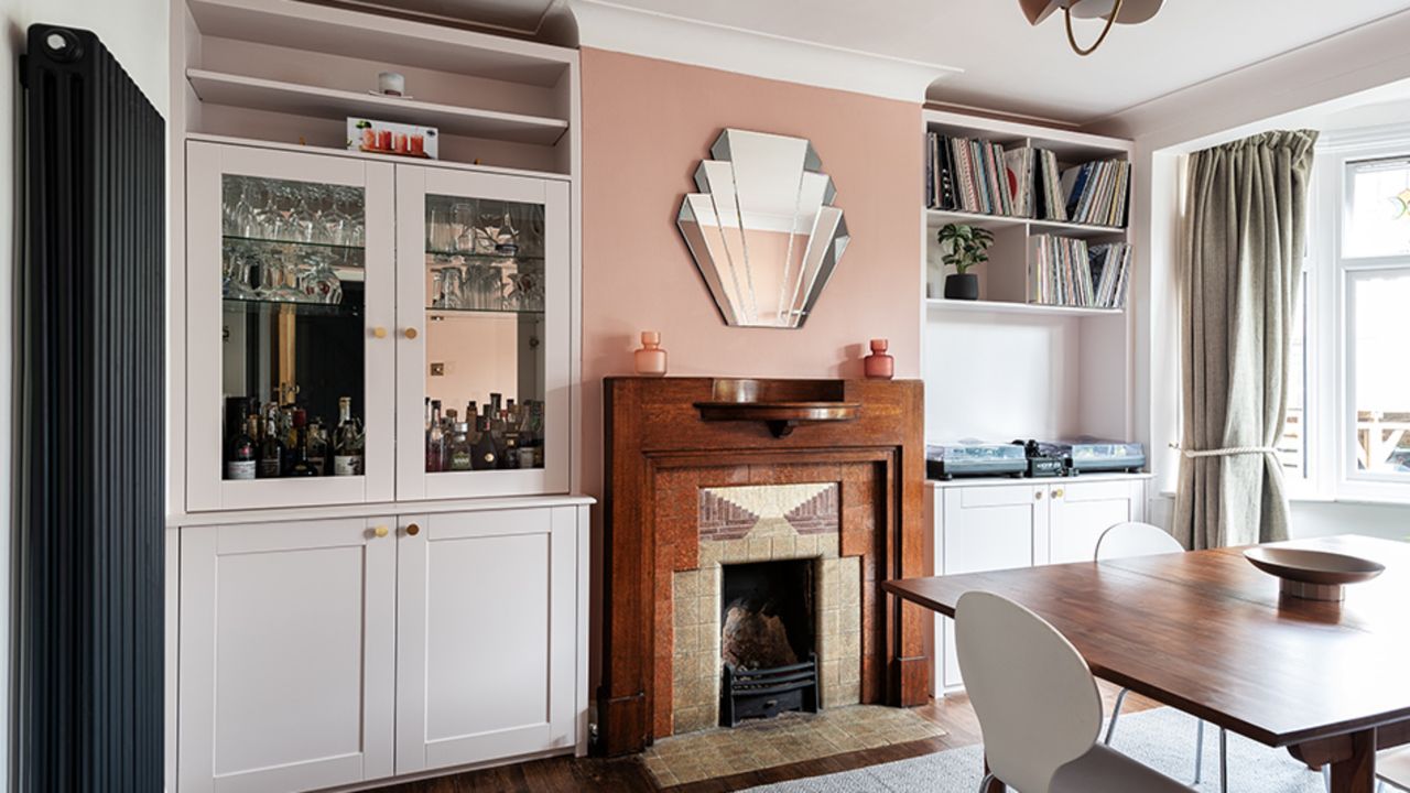 dining room with pink wall and period fireplace