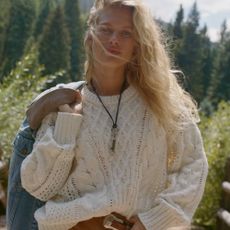 A model wearing a cream, knitted jumper from Abercrombie 
Fitch. 