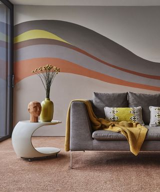 Creative paint idea on wall featuring sweeping sections in tonal grays, yellow and terracotta.