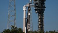 a large white-and-grey rocket stands upright on a launch pad