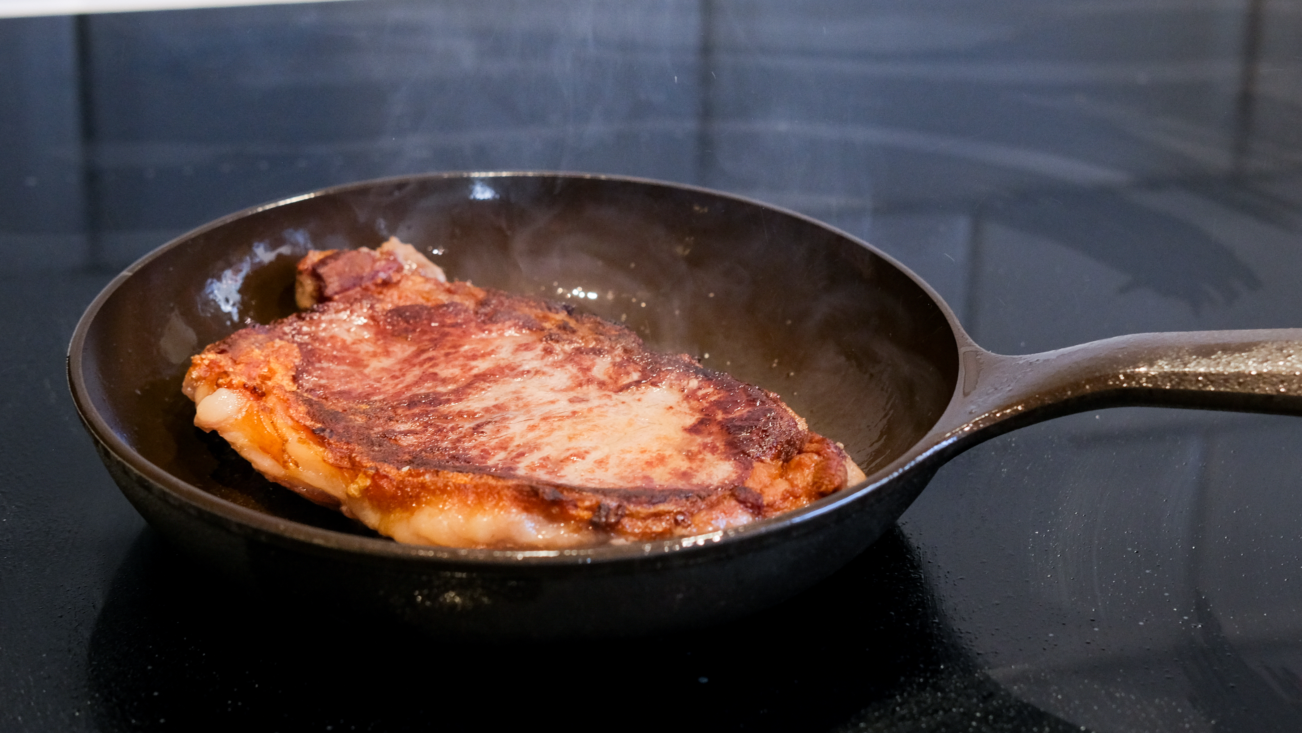 The Field Company Skillet being used to cook a steak