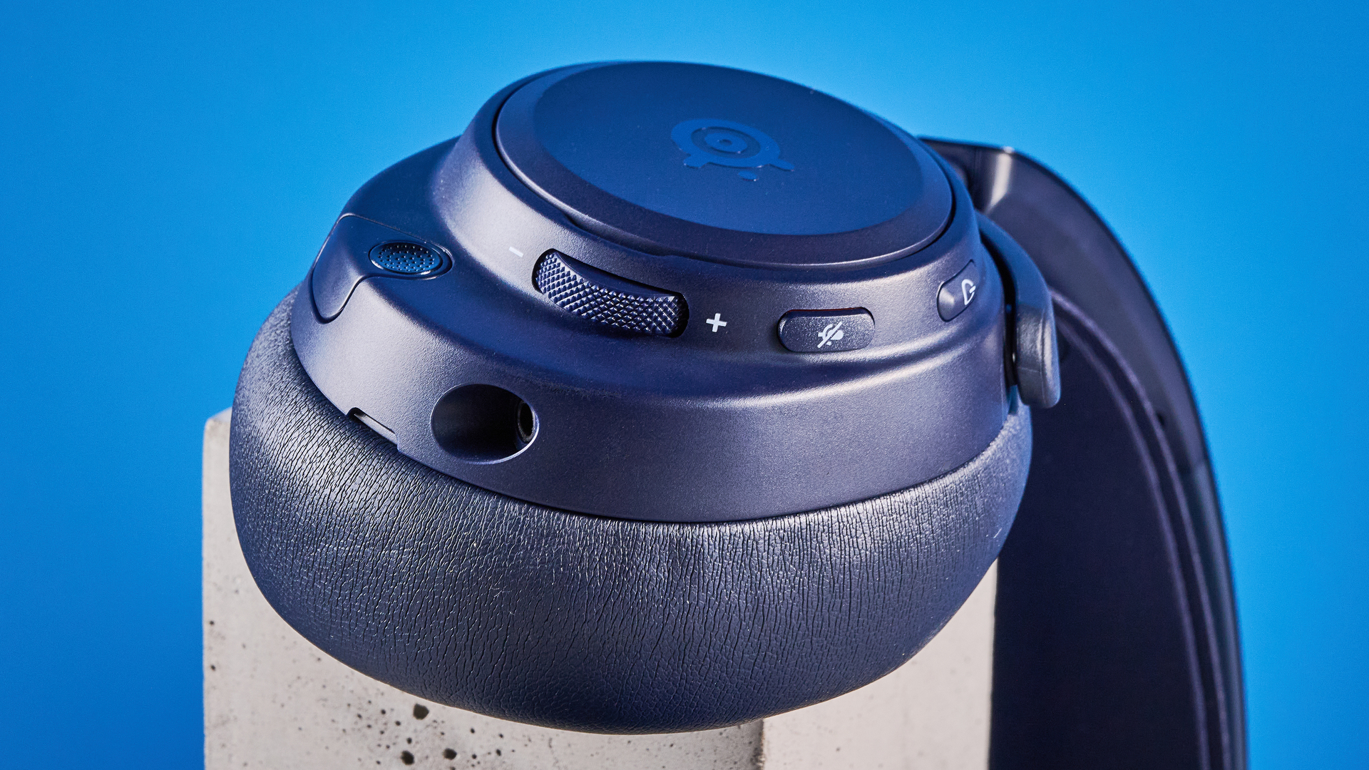 The SteelSeries Arctis Nova Pro Omni on a stone surface against a blue background