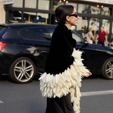 Alexis Badiyi wearing a feathered coat 