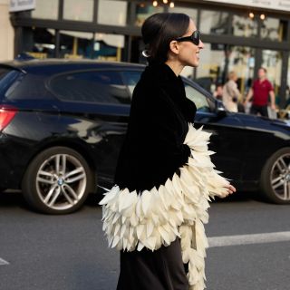 Alexis Badiyi wearing a feathered coat 