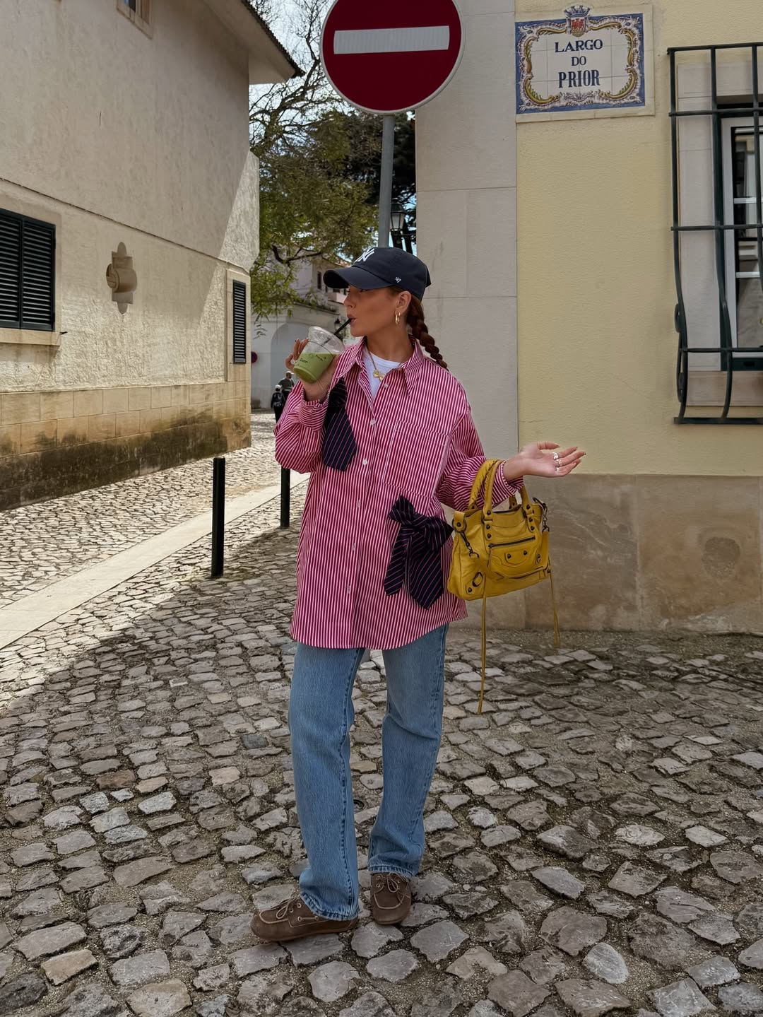 Influencer Rebecca Ferraz Wyatt wearing a striped shirt, straight jeans and boat shoes.