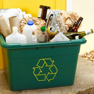 green bin with papers glass and plastic bottles