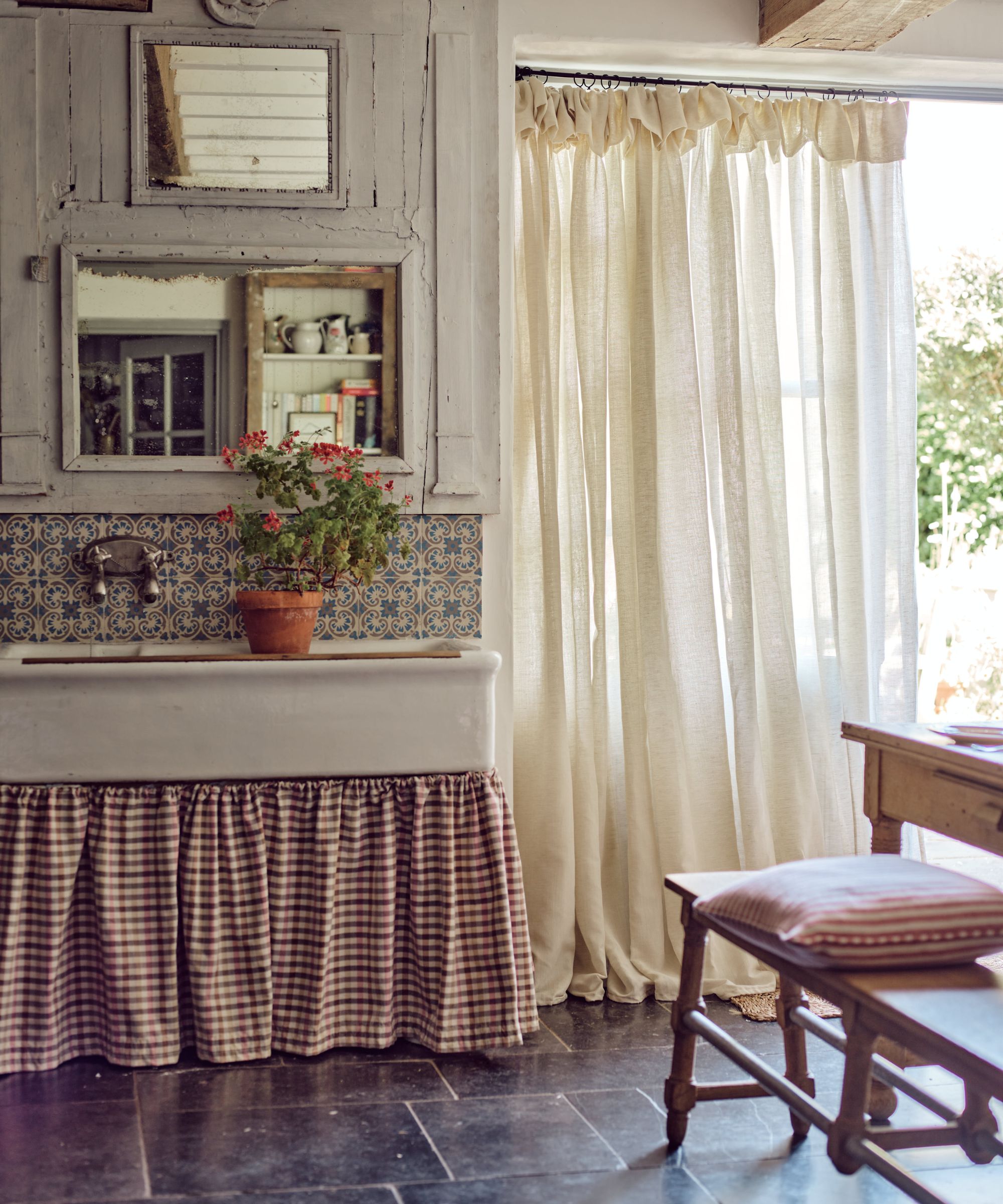 Rustic kitchen with vintage sink, fabric sink curtain and cream linen french door curtains