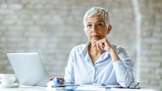 An older woman using AI on her laptop to learn about retirement options.