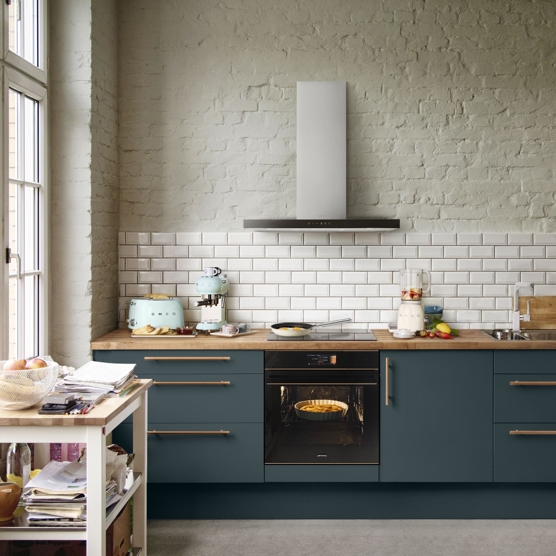 Modern kitchen ideas by Smeg, with sea green cabinetry, brass handles and a painted brick wall.