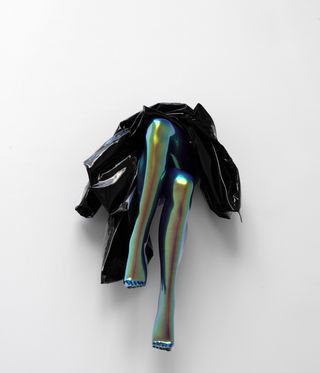 sculpture of folded raincoat across woman's legs