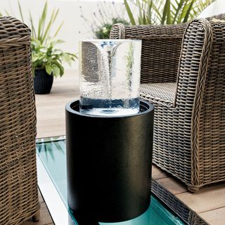 black water feature with wooden flooring and wooden chairs