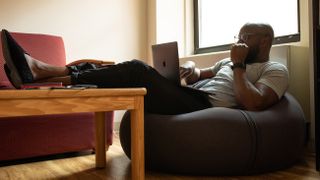 Self-isolation tips: Man sat on beanbag using laptop