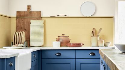 Two-tone kitchen ideas, small kitchen with dark blue base cabinets and yellow walls
