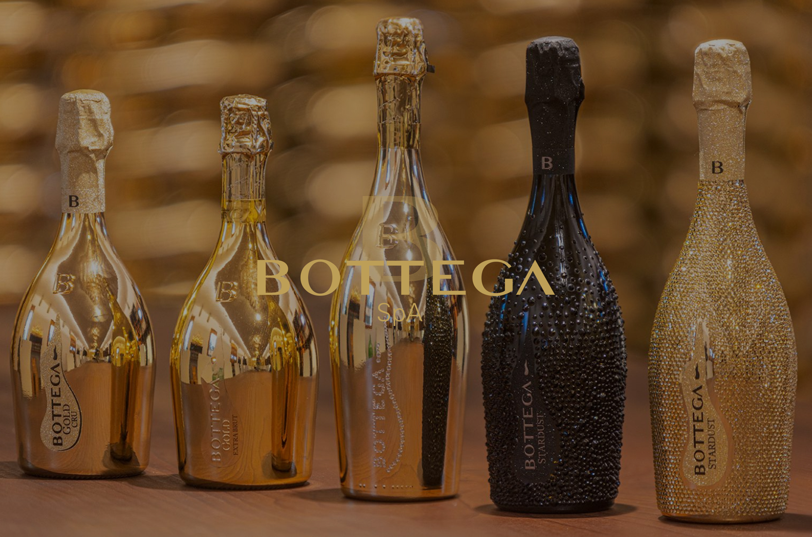 Five bottles of Prosecco: four gold and one black with gemstones
