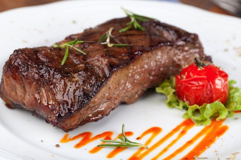 A steak sits on a dinner plate