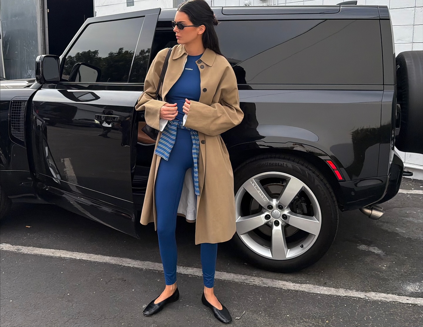 Kendall jenner wears a trench coat with an adanola top, adanola leggings, and ballet flats.