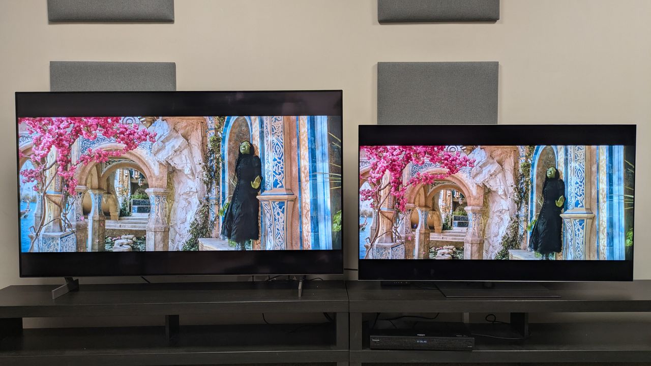 The LG B6 (left) and LG G6 (right) showing Wicked, with Elphaba stood under a pink-flowered tree. The pink flowers are much bolder on the G6, and the yellow stone has more punch