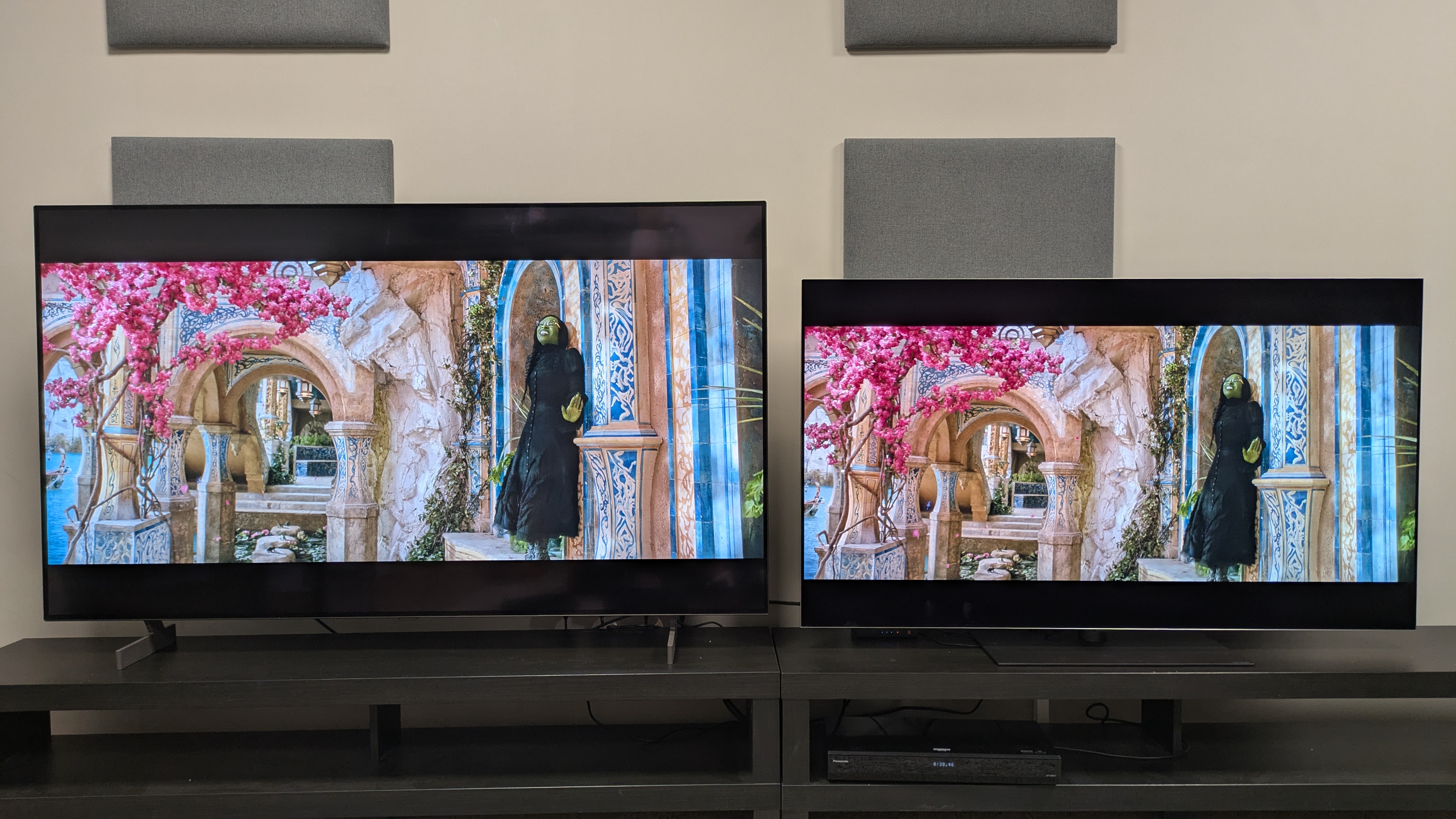 The LG B6 (left) and LG G6 (right) showing Wicked, with Elphaba stood under a pink-flowered tree. The pink flowers are much bolder on the G6, and the yellow stone has more punch