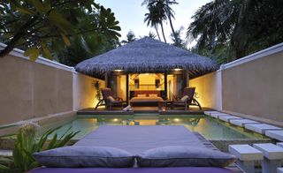 Pool area and day bed at Coco Bodu Hithi hotel in Maldives