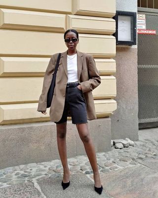 @sylviemus_ wearing black denim shorts, a blazer and heels