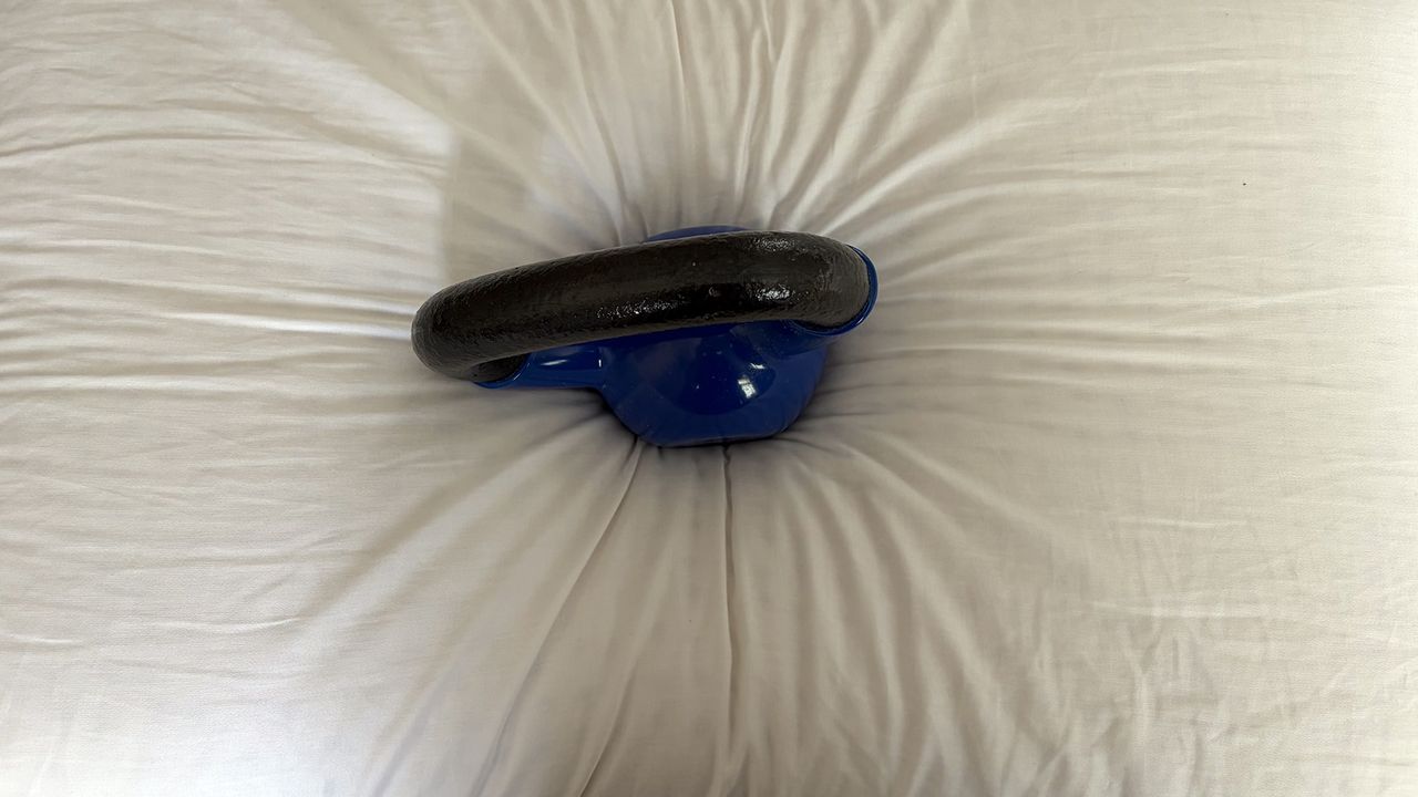 A close up of a 10lb kettlebell sitting on the Bearaby SoftForm Pillow