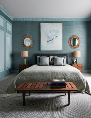 blue bedroom with gold wall lights