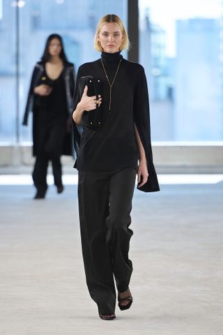 A Toteme runway model wearing an all-black outfit in the spring/summer 2025 collection.