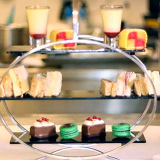 2-tiered tray containing desserts and sandwiches