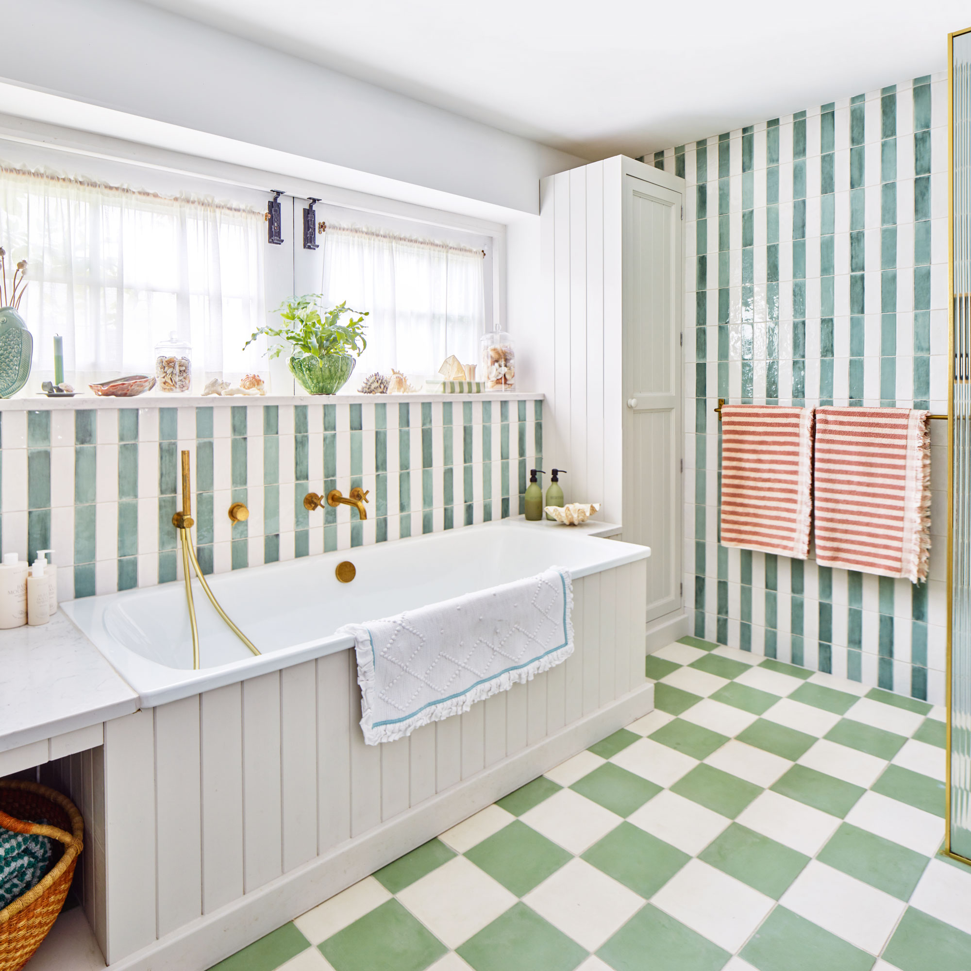 White built in bathtub with green check floor and blue stripe tiled wall