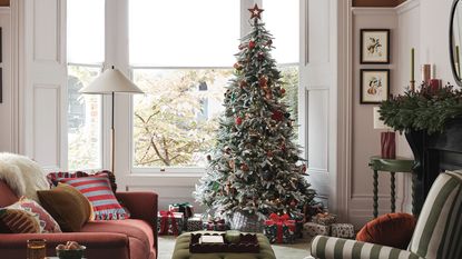 A snow-effect Christmas tree in a living room with decorations from the John Lewis Dawn &amp; Dusk range