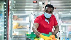 Man shopping in a supermarket with a mask