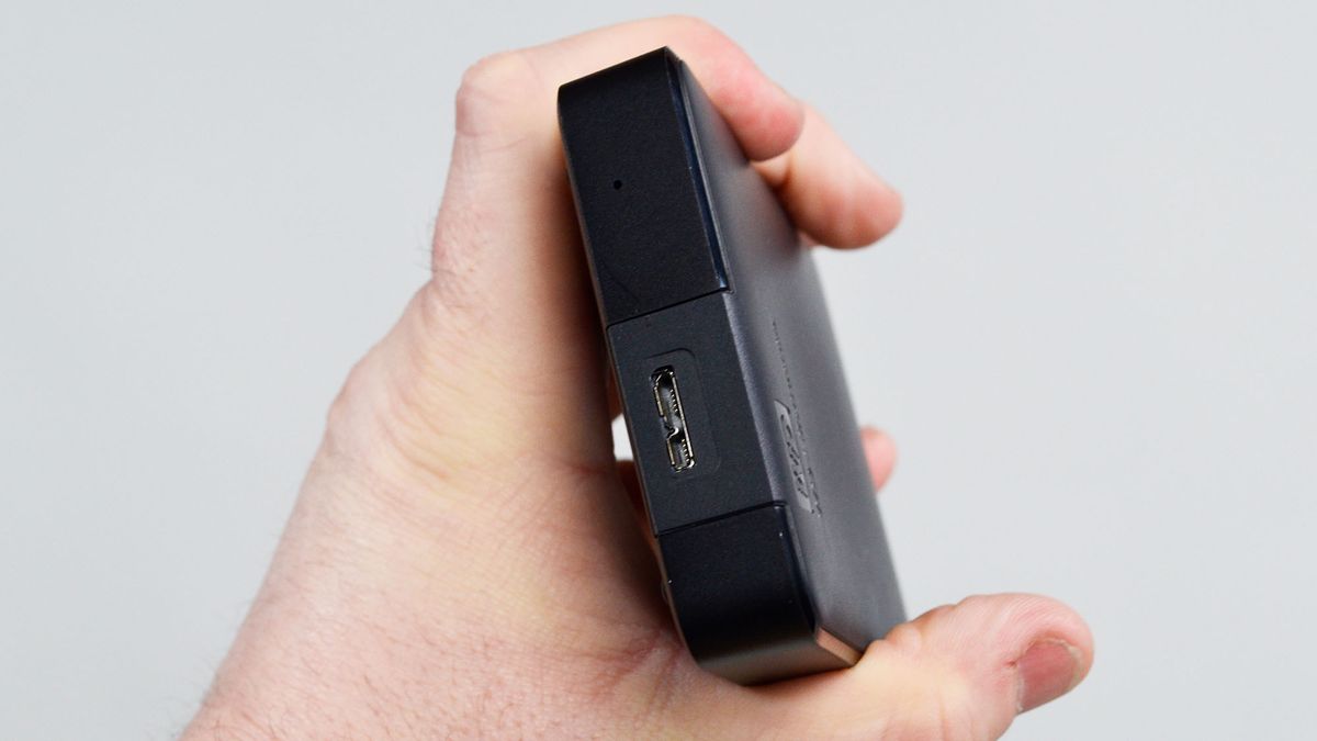 A msculine hand holding a WD Elements external hard drive