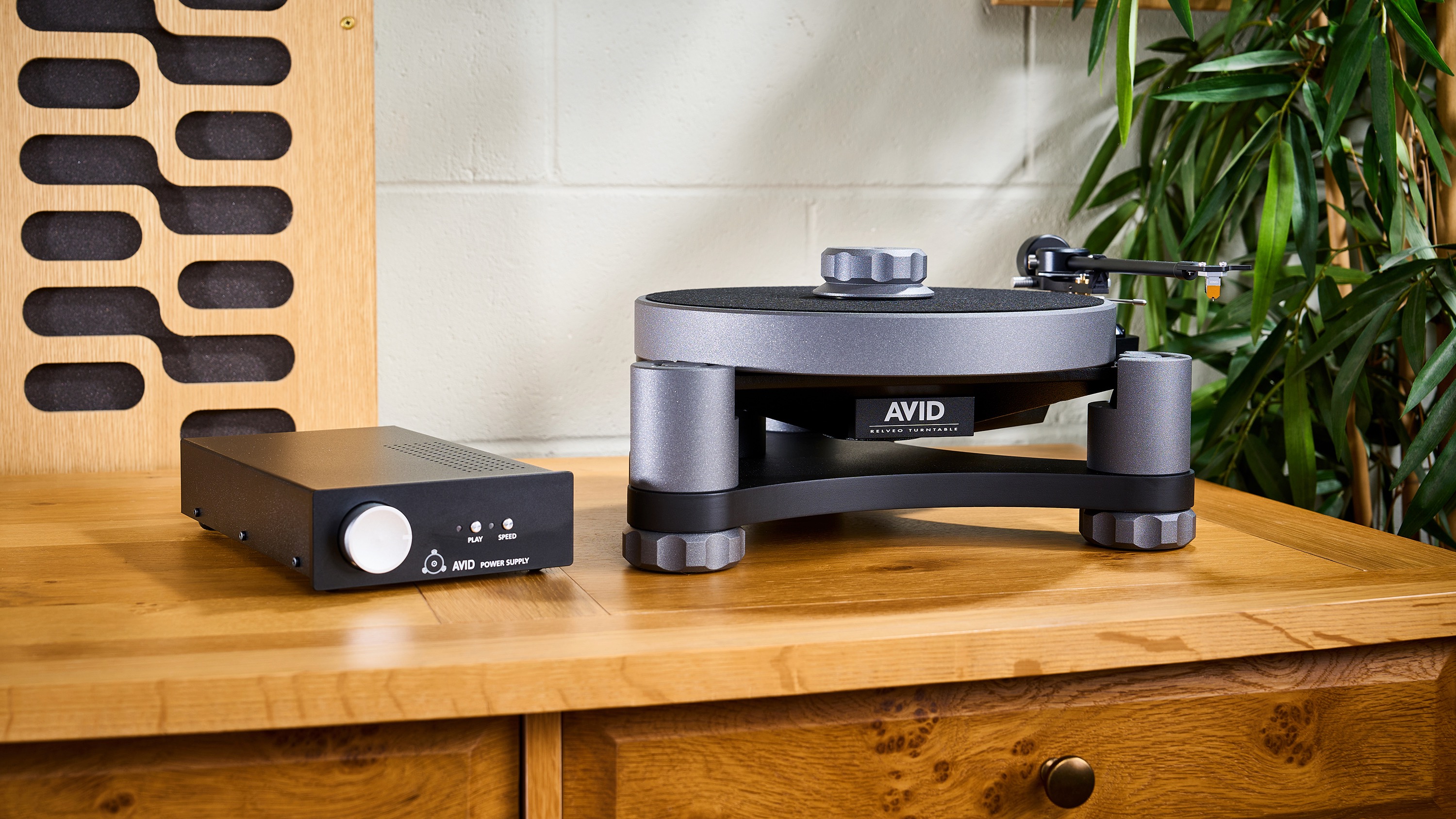 AVID Relveo turntable on wooden cabinet in warmly lit living room setting
