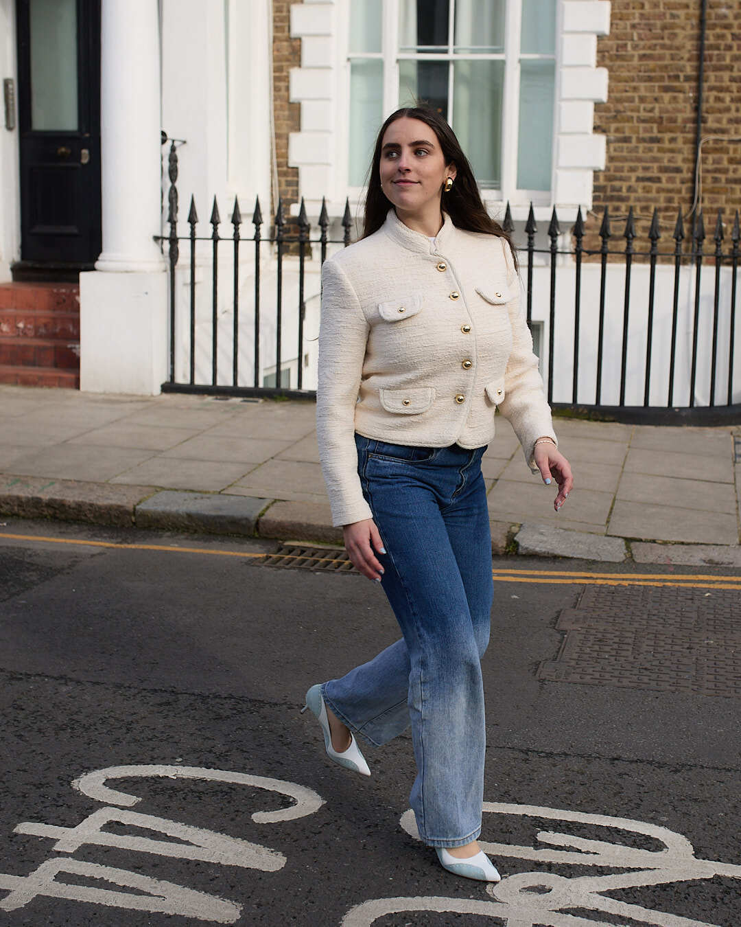Woman wears tweed jacket, blue jeans and blue and white heels