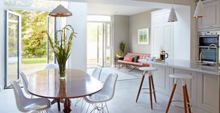 open-plan kitchen and dining area with two sets of French doors leading directly out onto a garden to show an idea of how to bring positive energy into your home
