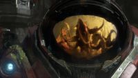A space marine's closed helmet reflects the oncoming zerg