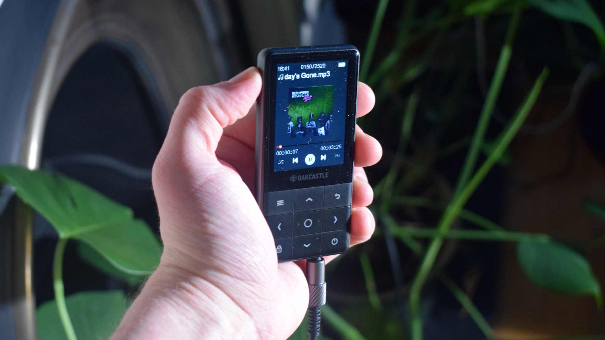 The Oakcastle MP300 in a man's hand, playing All American Rejects.