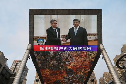 A TV shows Secretary of State Antony Blinken meeting with China's President Xi Jinping