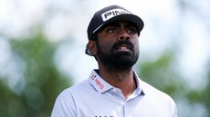 Sahith Theegala wearing a violet polo and black cap during a PGA Tour event