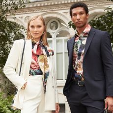 Male and Female model wearing Ted Baker suits and floral shirts